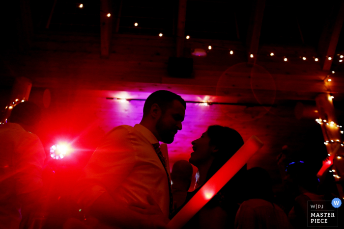 Photo des invités sur la piste de danse avec des lumières rouges vives par un photographe de mariage de Tunbridge, VT.