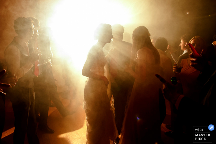 A photo of the bride and her guests obscured by light by a Paris wedding photographer.