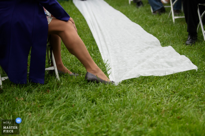 Photo: <a href="https://www.wpja.com/contests/2016-q4-photography-competition/details-found/1950251"> Janine Cooper - États-Unis </a> Un invité tient un tapis blanc avec son pied sur cette photo détaillée réalisée par un photographe de mariage à Omaha, NE.