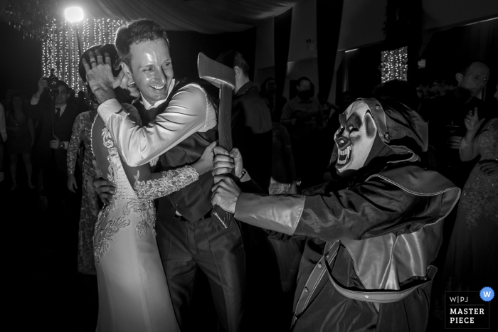 Photo by: <a href="https://www.wpja.com/contests/2016-q4-photography-competition/humor/1979991">Maykol Nack - Brazil</a> The groom shields his bride from a fake ax in this black and white photo by a Santa Catarina, Brazil wedding photographer.