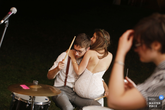 Foto door: <a href="https://www.wpja.com/contests/2016-q4-photography-competition/musicians-djs/1934121"> Sarah Priestap - Verenigde Staten </a> De bruid zit op de schoot van de drummer in deze foto door een Tunbridge, VT-huwelijksfotograaf.