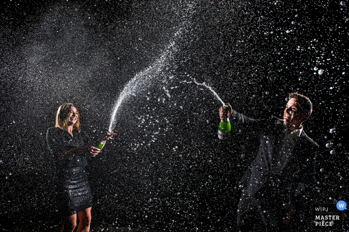 Boulder-Hochzeitsfotograf nahm dieses alberne Foto einer Braut und des Bräutigams gefangen, die mit Champagner sich duschen