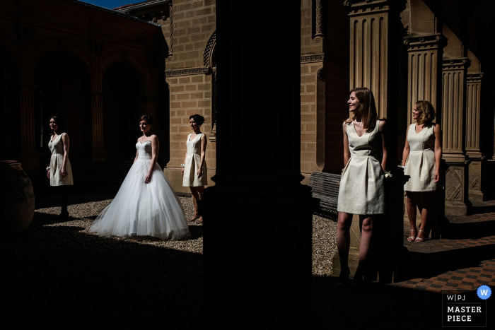 O fotógrafo de casamento de Lyon capturou esta imagem da noiva e das damas de honra posando em uma sala cheia de colunas