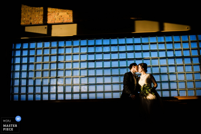 Chicago wedding photographer captured this image of a bride and groom kissing in front of a window