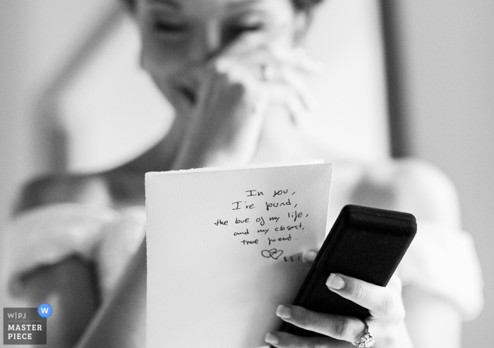 Barcelona wedding photographer captured this black and white image of a bride wiping tears from her eyes as she reads a card from her future husband