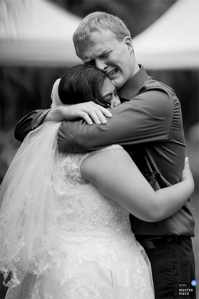 Il fotografo di matrimoni di San Diego ha creato questa immagine emotiva in bianco e nero di una sposa in un abbraccio