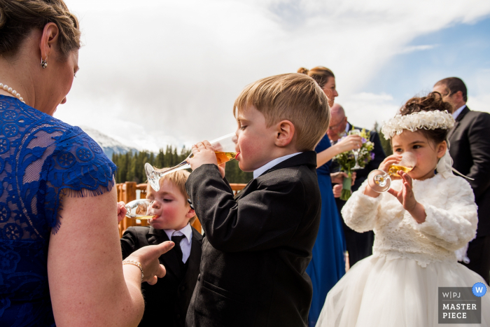 O fotógrafo de casamento de Alberta capturou esta imagem de crianças comemorando em uma recepção de casamento ao ar livre