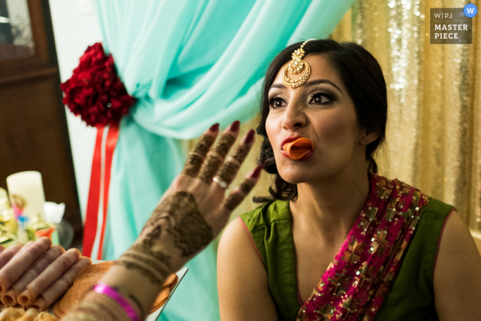 Alberta wedding photographer caught the bride getting some help eating, while protecting her makeup, before the wedding ceremony.