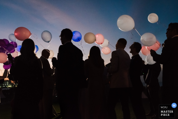 Il fotografo di matrimoni di Dubai ha catturato questa immagine degli invitati al matrimonio che tengono palloncini all'aperto al tramonto