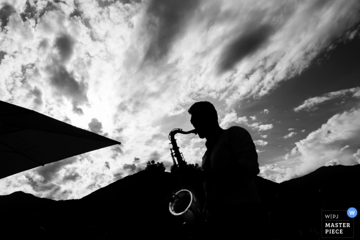Foto por: <a href="https://www.wpja.com/contests/2017-tri1-photography-competition/other-vendors/1997376"> Matteo Reni - Italia </a> El fotógrafo de bodas de Varese capturó esta silueta en blanco y negro de un saxofonista en una recepción al aire libre