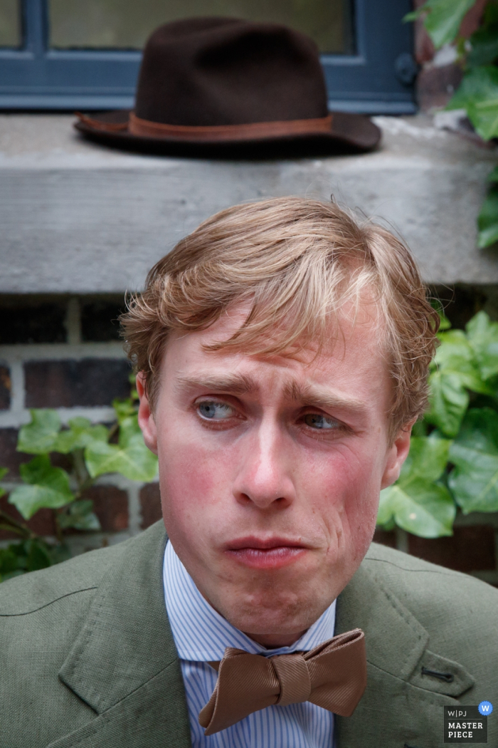 Photo: <a href="https://www.wpja.com/contests/2017-tri2-photography-competition/creative-portrait-groom/2049471"> Jacqueline Dersjant - Pays-Bas </a> Le photographe de mariage d'Amsterdam a capturé ce portrait des mariés alors qu'il est assis avec un air perplexe sur son visage et que son chapeau repose sur le rebord de la fenêtre derrière lui