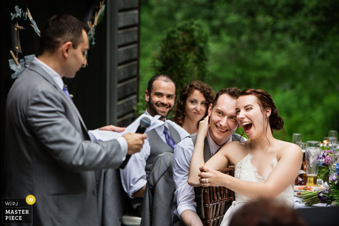 Photo by: <a href="https://www.wpja.com/contests/2017-tri2-photography-competition/toastingspeeches/2035426">Todd Laffler - United States</a> New Jersey wedding photographer captured this photo of a bride holding her groom close as they listened to speeches at their outdoor wedding reception