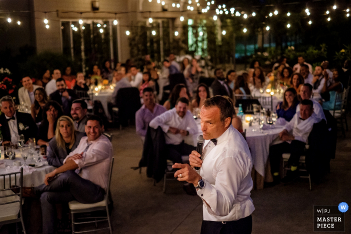 Il fotografo di matrimoni di San Diego ha catturato questa foto degli invitati al matrimonio ascoltando e ridendo di un discorso