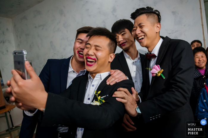 Photo by: <a href="https://www.wpja.com/contests/2017-tri2-photography-competition/mobile-devices/2044016">Ray Poon - China</a> ChongQing wedding photographer captured this silly photo of the groom taking a selfie with his friends while wearing the brides lipstick