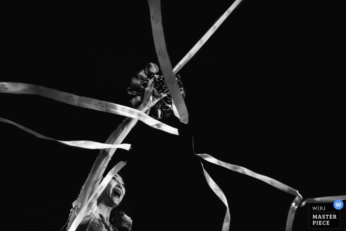 Fuzhou wedding photographer captured this image of a bride cutting the ribbons from her bouquet 