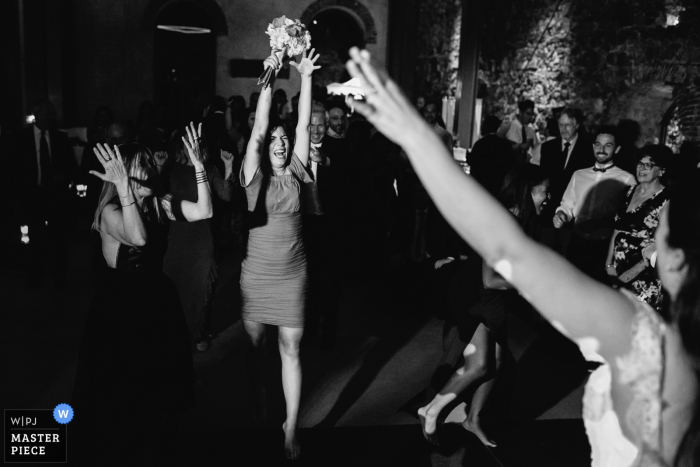 Photo by: <a href="https://www.wpja.com/contests/2017-tri2-photography-competition/bouquetgarter-action/2054171">Julian Kanz - Italy</a> Portofino wedding photographer captured this black and white photo of a wedding guest raising the bouquet she just caught in celebration