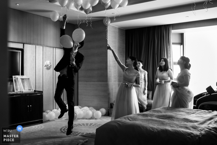Photo by: <a href="https://www.wpja.com/contests/2017-tri2-photography-competition/flowersdecorations/2039691">Vinci Wang - China</a> Fuzhou wedding photographer captured this image of a groomsmen getting instruction from a bridesmaid on some final balloon placement