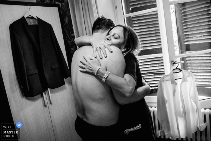 This black and white photo of the groom embracing his mother before he puts on his suit and jacket was captured by a Montpellier wedding photographer