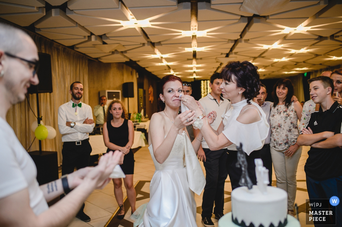 Photo: <a href="https://www.wpja.com/contests/2017-tri2-photography-competition/parents/2039491"> Linda Alexandriyska - Bulgarie </a> Un photographe de mariage en Bulgarie a surpris cette jeune femme qui demandait de l'aide en essuyant de la nourriture à la réception