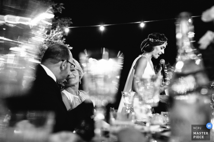 El fotógrafo de bodas de Portofino capturó esta imagen en blanco y negro de una novia que da su discurso mientras sus padres sonríen cerca