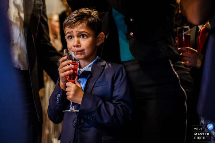 Photo by: <a href="https://www.wpja.com/contests/2017-tri3-photography-competition/food-drinks/2119921">Peter van der Lingen - Netherlands</a> A young boy is about to sip from a champagne glass in this photo by a Overijssel, Netherlands wedding photographer.