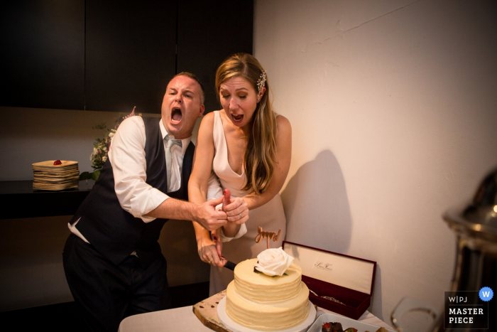 Foto door: <a href="https://www.wpja.com/contests/2017-tri3-photography-competition/cake-cutting/2101996"> Olya Vysotskaya - Verenigde Staten </a> De bruid houdt de hand van de bruidegom weg van het mes terwijl ze de eerste snede maakt in de bruidstaart op deze foto door een trouwfotograaf uit Brooklyn, NY.