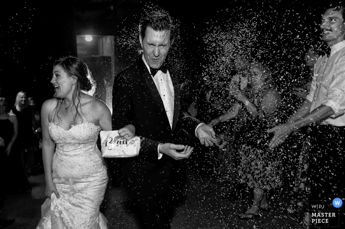 A Lake Tahoe, California wedding photo of a bride and groom walking towards the camera as rice is thrown at them