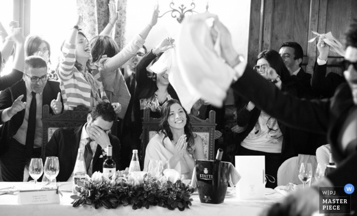 Photo by: <a href="https://www.wpja.com/contests/2013-q1-contest/reception/1141681">Raffaella Arena - Italy</a> Cosenza wedding photographer captured this black and white photo of the wedding guests toasting the bride and groom