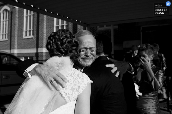 Un fotografo di matrimoni ha catturato questa foto emotiva in bianco e nero della sposa che abbraccia suo padre prima della cerimonia