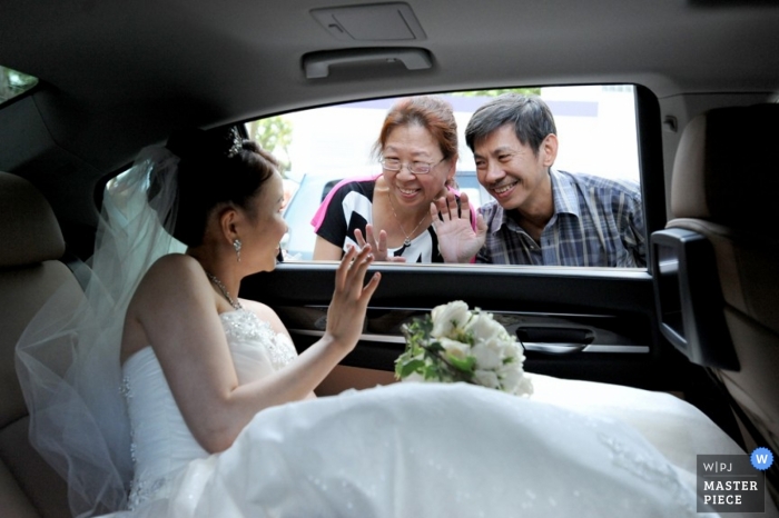 Photo: <a href="https://www.wpja.com/contests/2013-q1-contest/parents/1141441"> Adrian Ong - Singapour </a> La photographe de mariage de Singapour a capturé cette photo de la mariée en train de dire au revoir à ses parents depuis la fenêtre de la voiture