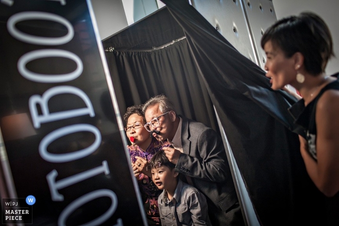 Photo de: <a href="https://www.wpja.com/contests/2013-q1-contest/parents/1148976"> Stephen Loh - Singapour </a> Le photojournalisme de mariage à Singapour - photo d'invités en train de profiter d'un photomaton à la réception