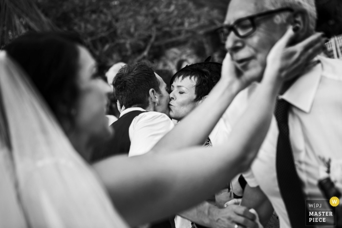Le photographe de mariage à Bali a capturé cette photo en noir et blanc de la mariée tenant tendrement le visage de son père avant la cérémonie en Indonésie