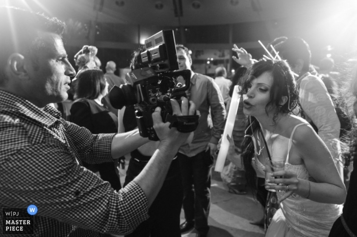 El fotógrafo de bodas de Tel Aviv capturó esta imagen en blanco y negro de la novia posando para una foto tomada por otro fotógrafo