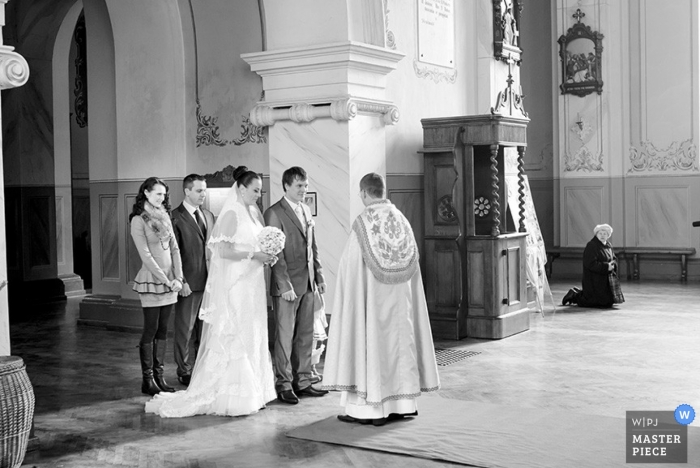 Der litauische Hochzeitsfotograf hat dieses Schwarz-Weiß-Foto aufgenommen, auf dem Braut und Bräutigam bei der Zeremonie ihr Eheversprechen ablegen