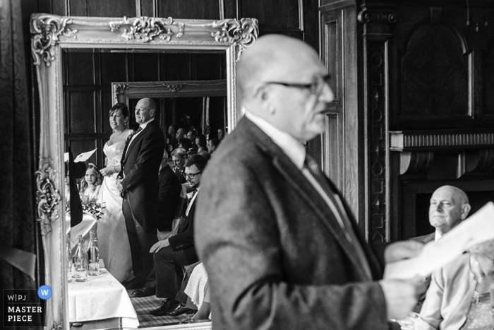 Foto door: <a href="https://www.wpja.com/contests/2013-q1-contest/full-frame-black-and-white/1149411"> Jonathan Brown - Verenigd Koninkrijk </a> De trouwreportagefotograaf van Newcastle heeft deze zwart-witfoto van de bruid en bruidegomsreflectie tijdens hun geloften vastgelegd