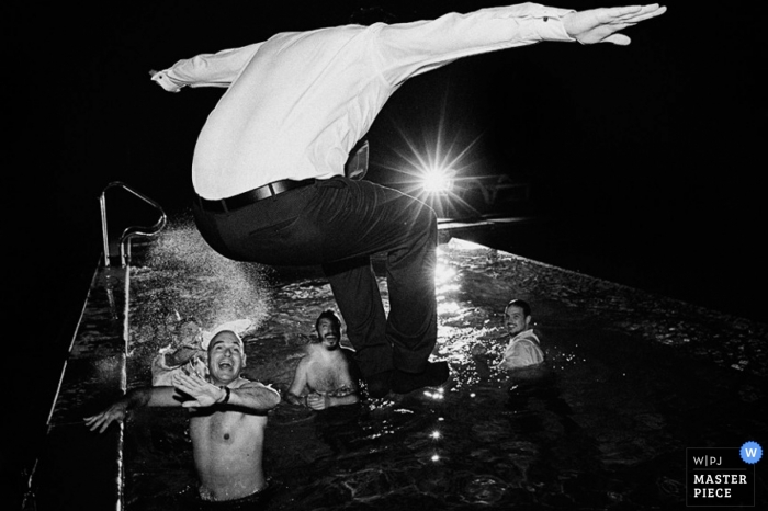 El fotógrafo de bodas de Buenos Aires capturó esta foto en blanco y negro del novio saltando completamente vestido en la piscina