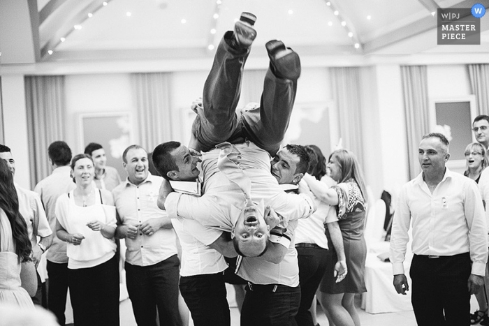 Photo de: <a href="https://www.wpja.com/contests/2013-q2-contest/reception/1187061"> Nikola Smernic - Croatie </a> Photographie de mariage documentaire en Croatie | L'image contient: marié, à l'intérieur, réception, noir, blanc, invités de mariage, garçons d'honneur