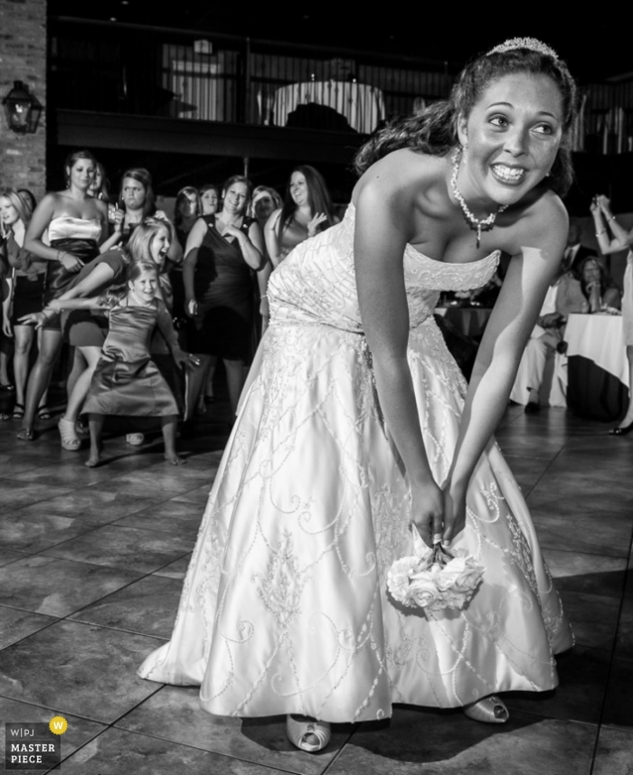 Photo: <a href="https://www.wpja.com/contests/2013-q2-contest/reception/1192926"> Tyler Vance - États-Unis </a> Photographie de mariage documentaire à Baton Rouge | L’image contient: bouquet de mariée, intérieur, noir, blanc, mariée, invités au mariage