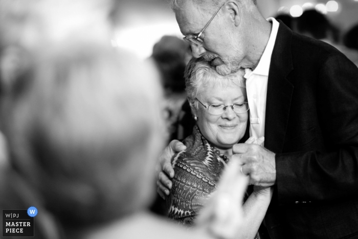 Photo: <a href="https://www.wpja.com/contests/2013-q2-contest/reception/1211876"> Kevin Trimmer - États-Unis </a> Photographe de mariage documentaire Providence | L'image contient: invités au mariage, étreindre, danser, noir, blanc, réception