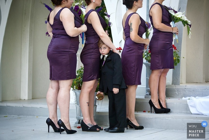 Foto por: <a href="https://www.wpja.com/contests/2013-q2-contest/kids-being-kids/1194751"> Cindy Brown - Estados Unidos </a> Fotógrafo de bodas en Atlanta | La imagen contiene: ceremonia, color, novias, púrpura, flores, niño