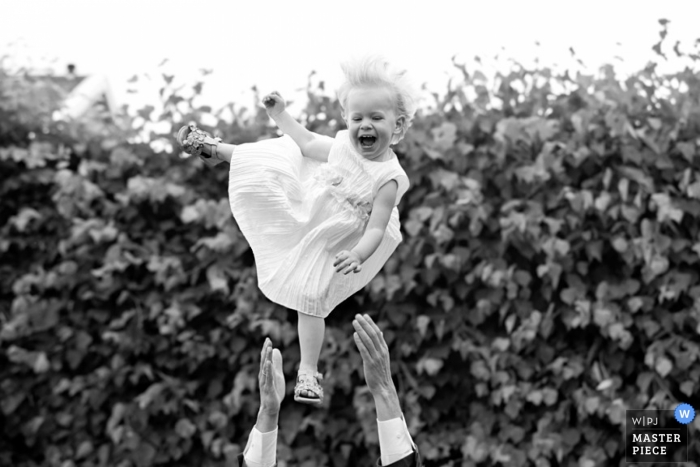 Foto por: <a href="https://www.wpja.com/contests/2013-q2-contest/kids-being-kids/1200276"> Gerhard Nel - Países Bajos </a> Fotografía de la boda de Zuid Holland | La imagen contiene: bebé, brazos, arbustos, negro, blanco, exterior