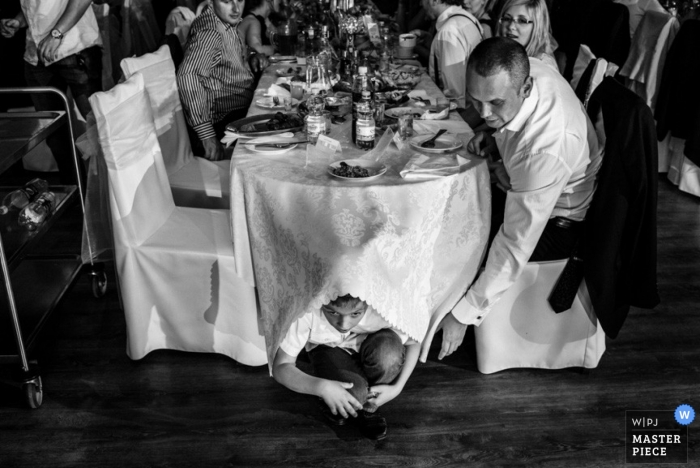 Fotografía de la boda de Varsovia | La imagen contiene: recepción, negro, blanco, mesa, niño, invitados a la boda