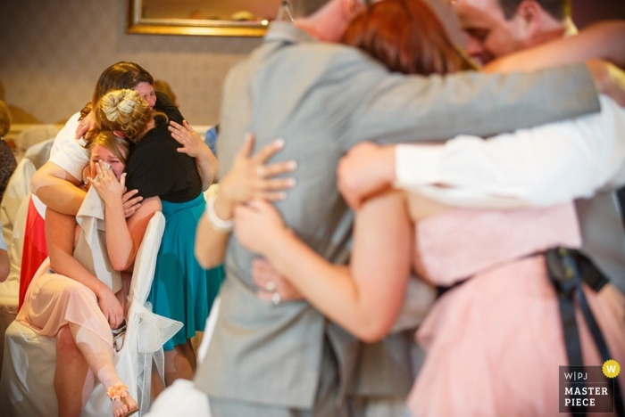 Photo par: <a href="https://www.wpja.com/contests/2013-q2-contest/emotion/1165441"> David Butler II - États-Unis </a> Photographie de mariage à Hartford | L'image contient: câlins, pleurs, intérieur, couleur, invités au mariage