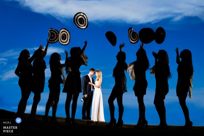 Tel Aviv Wedding Photography | Image contains: portrait, hats, sunset, blue, couple, bridemaids, light