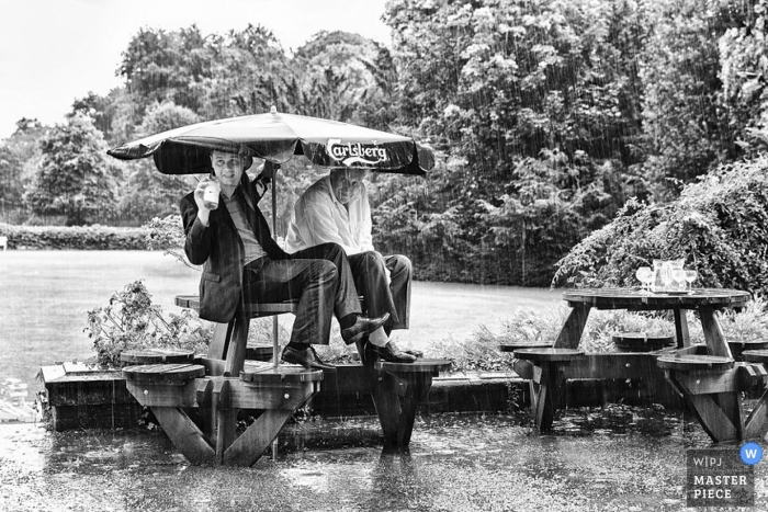 Foto von: <a href="https://www.wpja.com/contests/2013-q3-contest/weather/1270171"> Ian Bursill - Großbritannien </a> Dokumentarische Hochzeitsfotografie in Leicestershire | Bild enthält: Regen, Regenschirm, unten, gießen, getränkt