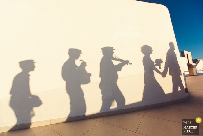 Foto von: <a href="https://www.wpja.com/contests/2013-q3-contest/musicians-djs/1246191"> Yana Zharintsova - Russia </a> Sankt Petersburg Braut und Bräutigam Fotografie | Schatten an der Wand der Musiker nach der Zeremonieparade