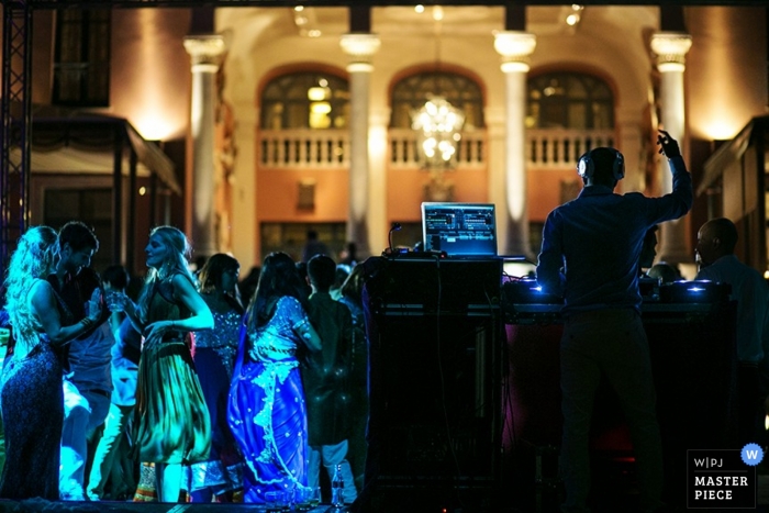 Wedding Photography in Madrid | Image contains: reception, blue lights, dj, dancing, guests, pillars