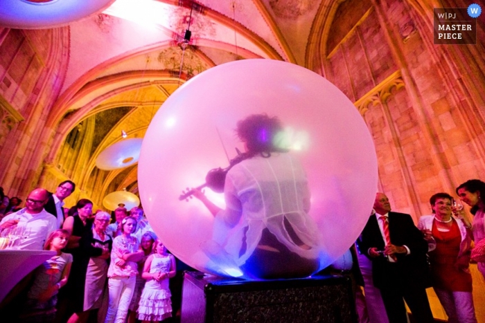 Fotografia di matrimonio in Olanda Meridionale | L'immagine contiene: chiesa, colore, musicista, bolla, colore, ricevimento, invitati al matrimonio