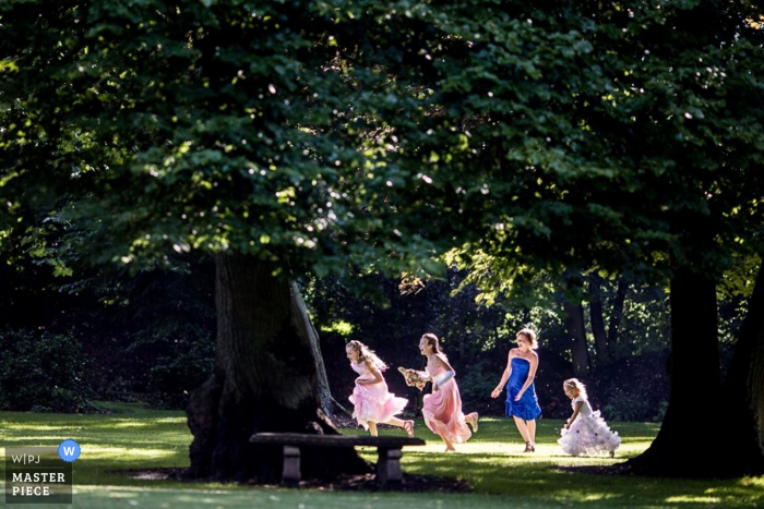 Lower Saxony wedding picture of girls running and playing in the grass under the trees