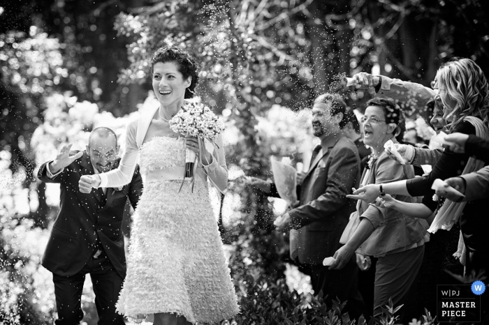 Photo by: <a href="https://www.wpja.com/contests/2014-q1-photography-contest/ceremony/1391126">Andrea Corsi - Italy</a> Arezzo Wedding Photography in Tuscany | Image contains: groom, bride, rice, ceremony, flowers, guests, black, white